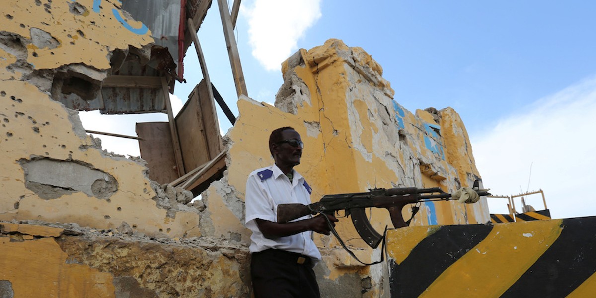 A Somali traffic policeman stands guard near the scene of a suicide car bomb explosion outside the traffic police headquarters in Somalia's capital Mogadishu May 9, 2016.