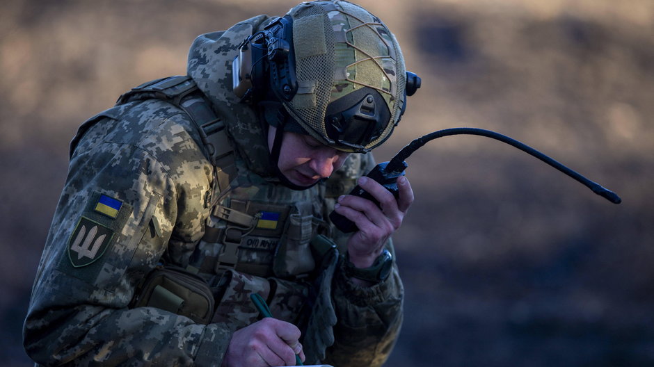 Ukraiński żołnierz otrzymuje instrukcje przez radiotelefony na linii frontu w Donbasie