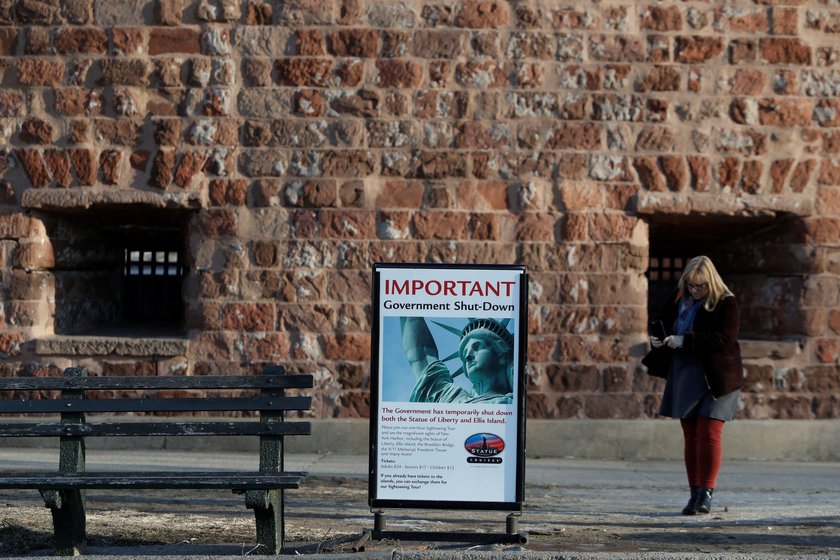 A sign announcing the closure of the Statue of Liberty, due to the U.S. government shutdown, sits ne