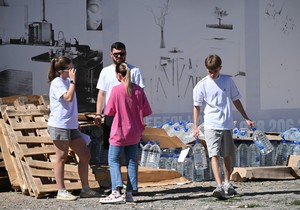 Lokalni stanovnik nosi flaše sa vodom za piće iz humanitarne pomoći koju su dopremili volonteri u Džankoju na Krimu
