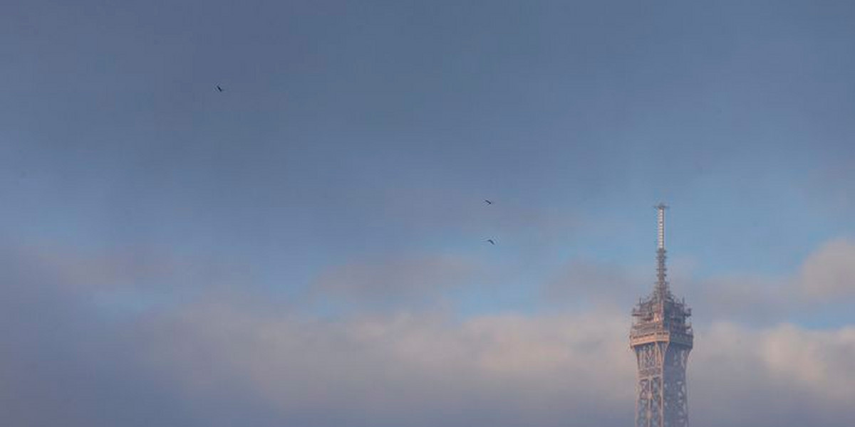The Eiffel Tower is partially covered by an early morning fog in Paris