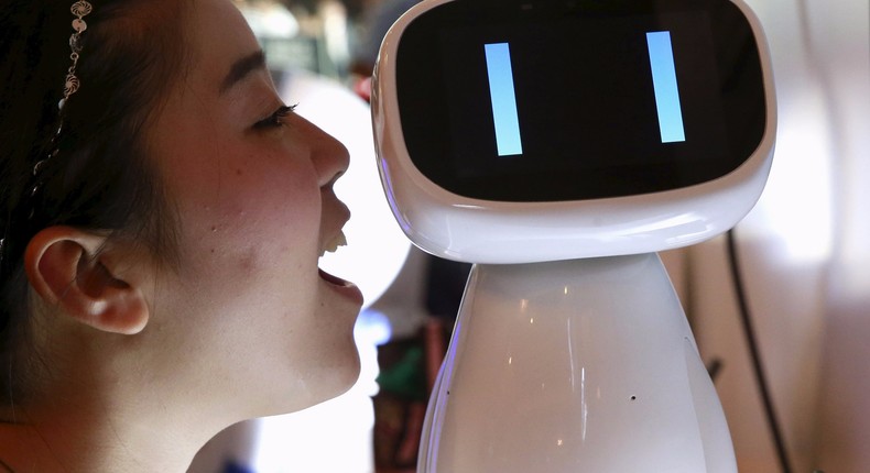 A visitor speaks to Baidu's robot Xiaodu at the 2015 Baidu World Conference in Beijing, China, September 8, 2015.