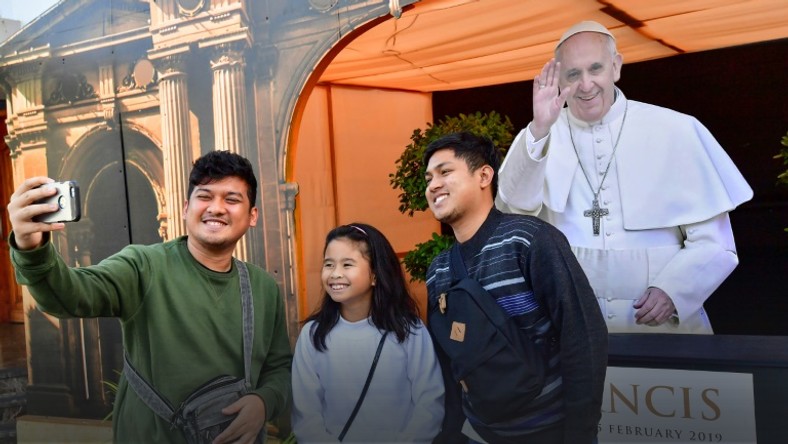 Worshippers pose for a selfie with a cutout image of Pope Francis at St Mary's Catholic Church in Dubai on January 30, 2019, days ahead of his visit to the United Arab Emirates