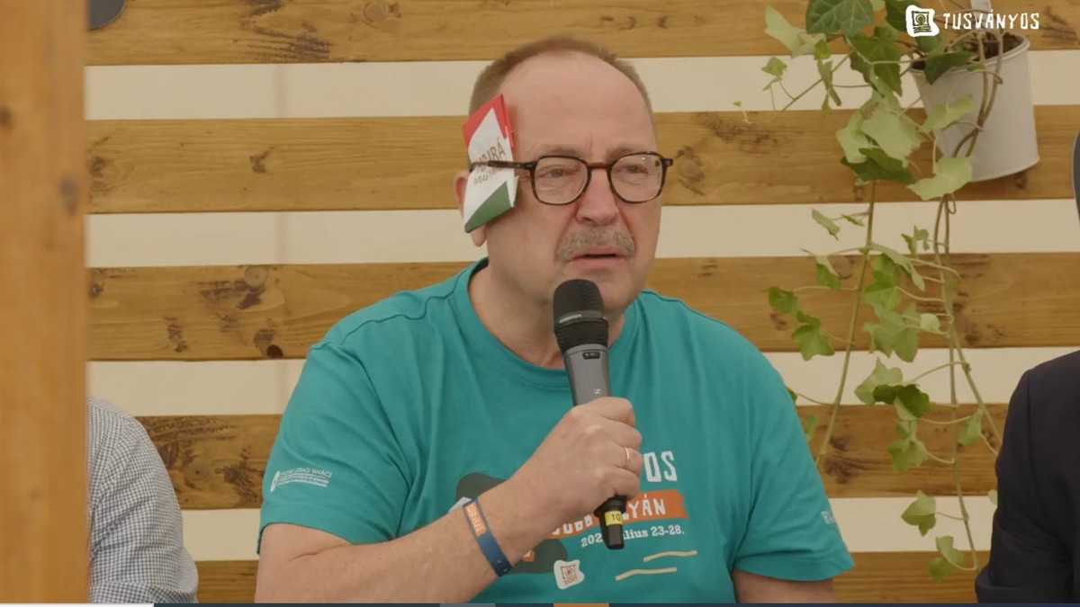 Az idei divat Tusványoson: a Fidesz alapító tagja kiállt Trump mellett, egy matricával takarta el a jobb fülét – videó