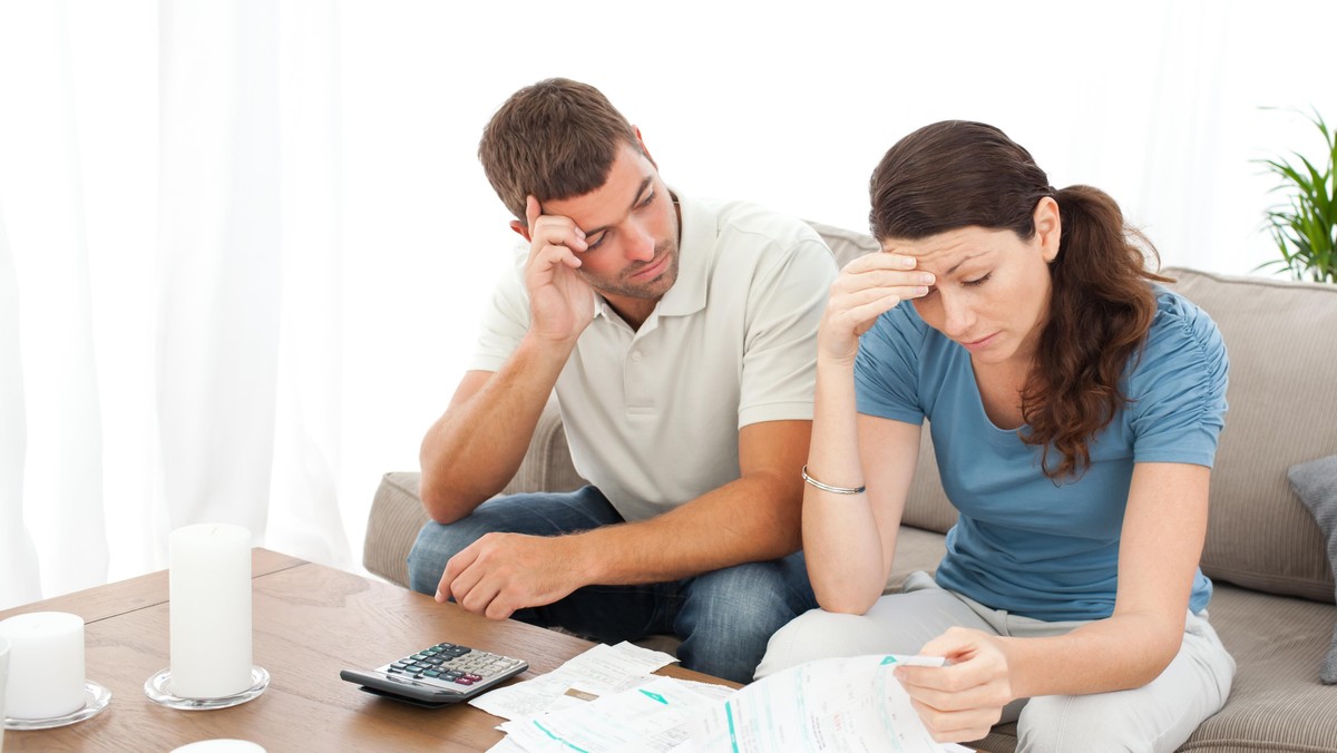 Worried couple doing their accounts in the living room