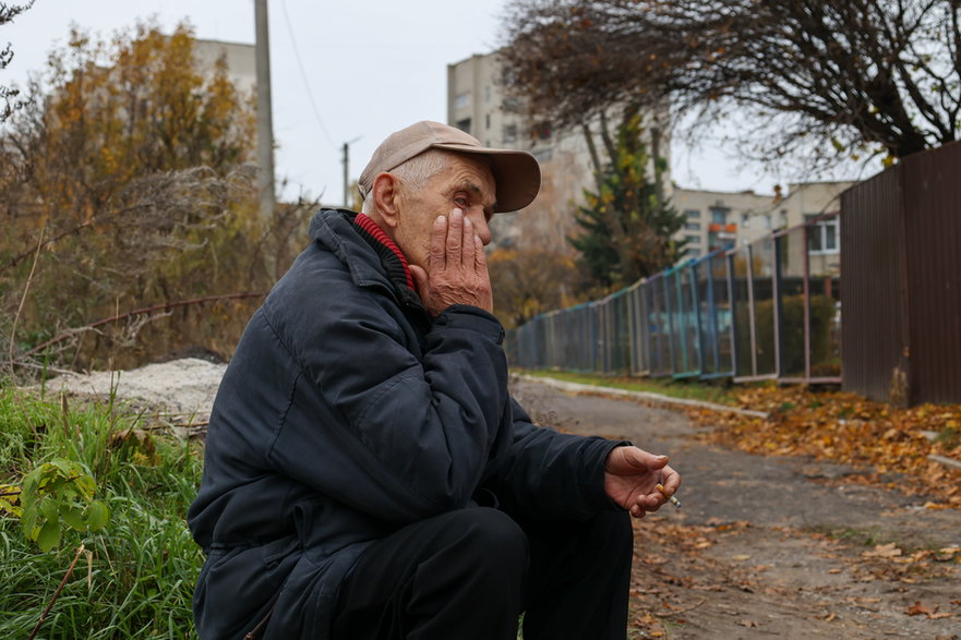 Starszy mężczyzna czekający w kolejce osób, które chcą przekazać swoje DNA w celu identyfikacji zmarłych krewnych w Izium w obwodzie charkowskim, 4 listopada 2022 r.