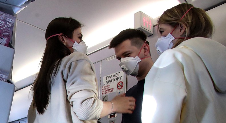 Passengers wearing face masks on board a plane at Geneva Airport.