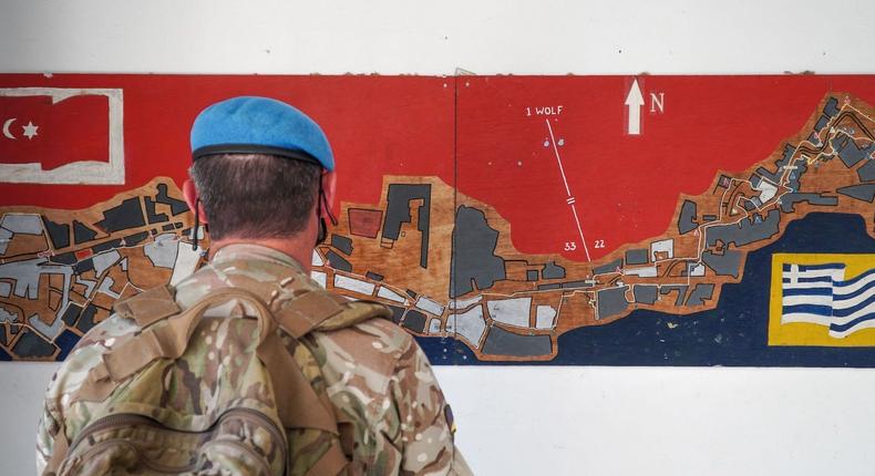 A member of the UN Peacekeeping Force in Cyprus looks at a map of the buffer zone between the internationally recognized Republic of Cyprus and the Turkish Republic of Northern Cyprus, recognized only by Ankara, in the divided capital Nicosia on April 26, 2021.ROY ISSA/AFP via Getty Images