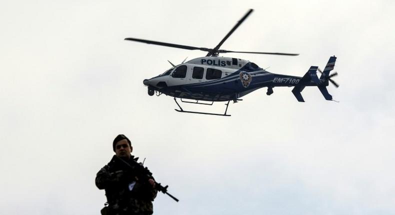 A police helicopter flies overhead as defendants are escorted towards the courthouse in Mugla, western Turkey, on February 20, 2017