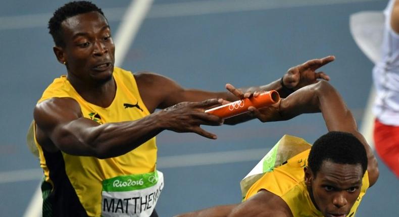 Jamaica's Nathon Allen (right) grabs the baton from Peter Matthews as they compete in the Men's 4x400m Relay Final at the Rio 2016 Olympic Games on August 20, 2016