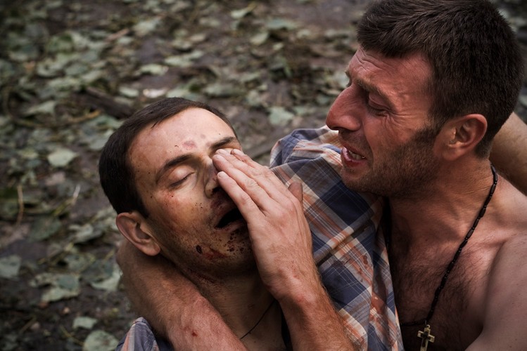 Mężczyzna trzyma ciało krewnego, który zginął podczas rosyjskiego ataku na trzy cywilne budynki w Gori, 9 sierpnia 2008