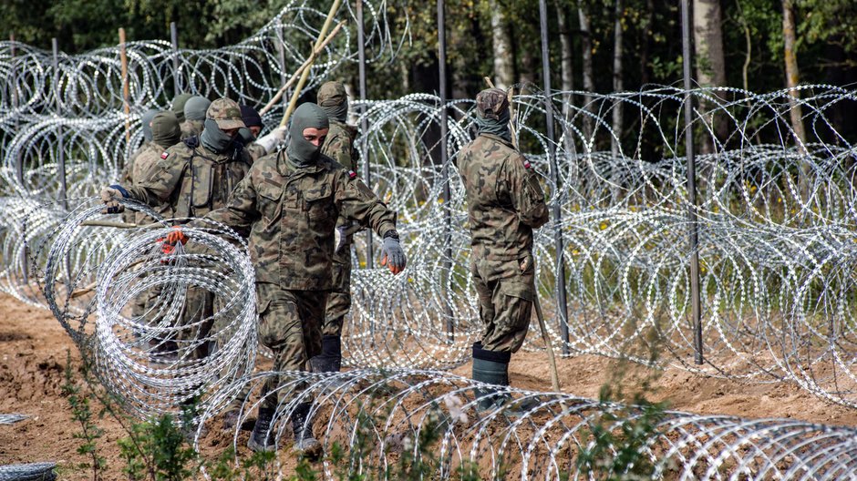 Polscy żołnierze stawiają zasieki na granicy polsko-białoruskiej, wrzesień 2021 r.