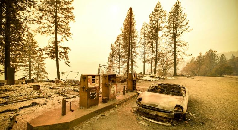 A burnt car and a gas station remain visible on November 11, 2018 after the Camp fire tore through the region near Pulga, east of Paradise, California