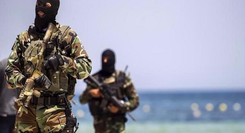 File photo of Tunisia's special forces securing the beachside of the Imperial Marhaba resort, while British, French, German and Tunisia's interior minister arrive to pay their tribute in front of a makeshift memorial in Sousse.