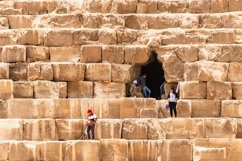 Turyści na piramidzie w Gizie