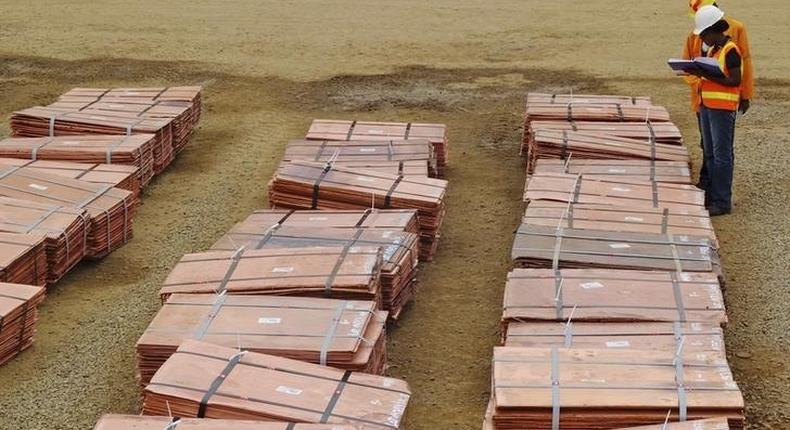 Workers at Tenke Fungurume, a copper mine in the southern Congolese province of Katanga, check bundles of copper cathode sheets ready to be loaded and sent out to buyers January 29, 2013. REUTERS/Jonny Hogg