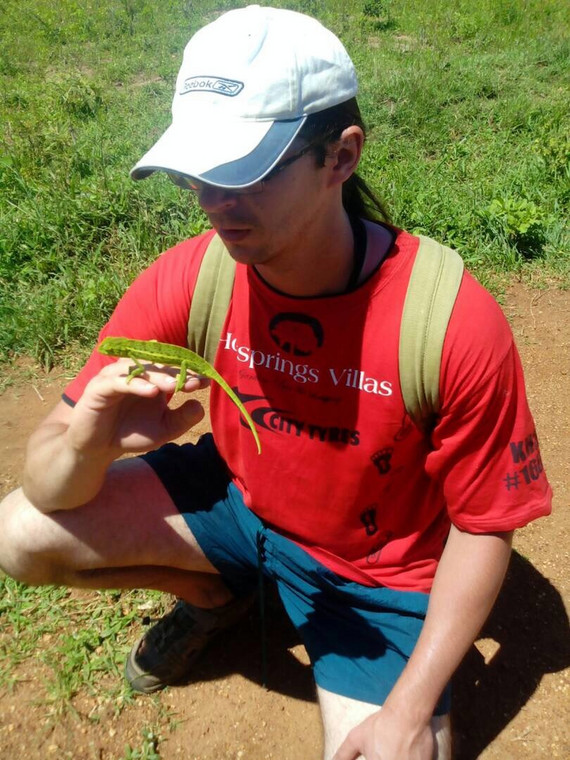 Damian Małaszewski z kameleonem znalezionym przy drodze w Ugandzie