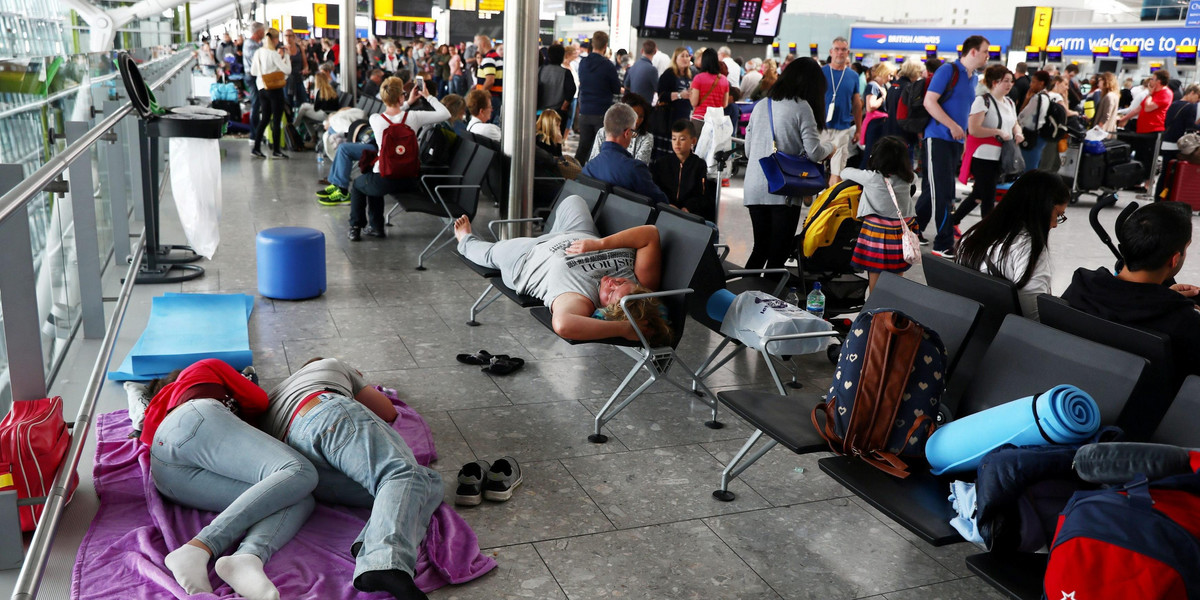 FILE PHOTO:People sleep next to their luggage at Heathrow Terminal 5 in London