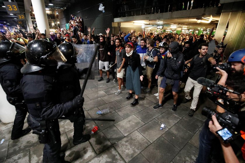 Passengers look as a police officer walks past at Barcelona's airport, during a protest after a verd