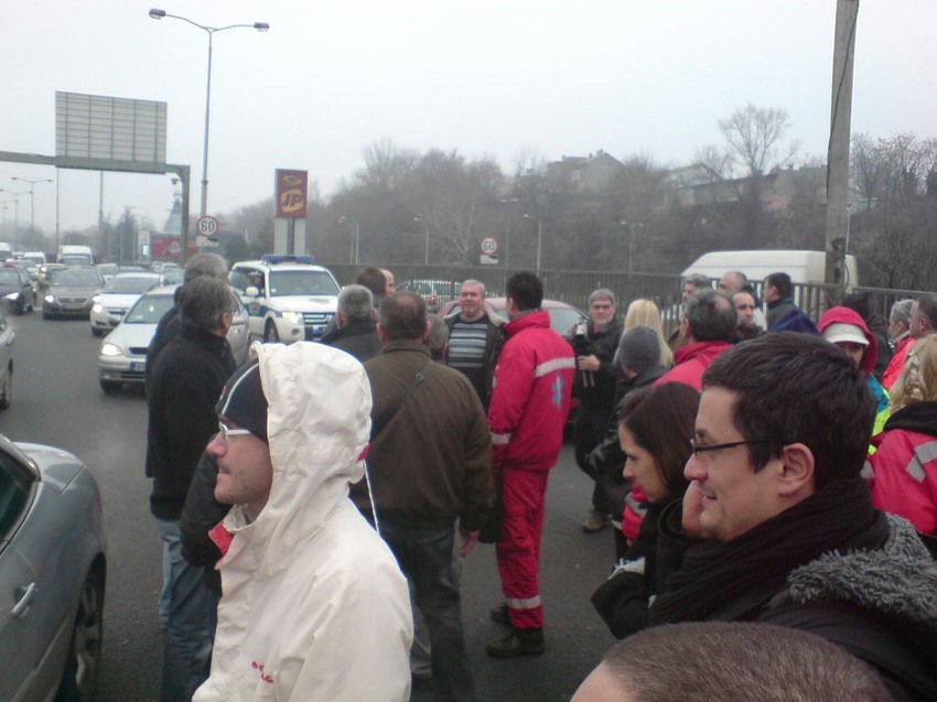 Radnici Hitne pomoći na protestu na autoputu u Beogradu   Radnici ističu da plate nisu dobili jer se u budžetu pojavio manjak od 40 miliona dinara, a sve, kako navode, zbog toga što je u tu službu primljeno mnogo više radnika nego što je potrebno.   Nezadovoljnih radnici Hitne pomoći danas su imali sastanak sa direktorom te službe Nenadom Ivančevićem, gradskom sekretarkom za zdravstvo Verom Dražić i državnim sekretarom Ministarstva zdravlja Vladimirom Đukićem.   Ivančević, Dražićeva i Đukić su nakon sastanka na kome su saslušali probleme zaposlenih otišli u Ministarstvo zdravlja gde su na sastanku sa direktorom Republičkog fonda za zdravstveno osiguranje, ali i predstavnicima Ministarstva zdravlja pokušali da nađu rešenje za taj problem.   - Na strani sam ovih ljudi koji je trebalo da dobiju platu, kao i svi drugi uoči Nove godine. Čim samo saznali za problem odmah smo se uključili i činimo sve da ga prevaziđemo. Nažalost, danas im ne možemo dati platu i veoma nam je žao što Hitna pomoć, koja je kičma zdravstvenog sistema u Beogradu, jedina nije dobila platu. Garantujemo im da će platu dobiti posle Nove godine, odnosno prvog radnog dana. Na sastanku u Ministarstvu pokušaćemo da nađemo rešenje za dug od 40 miliona dinara - kazala je Vera Dražić, gradska sekretarka za zdravstvo.