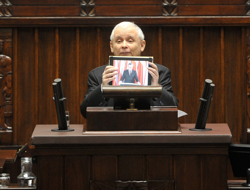 Jarosław Kaczyński trzyma tablet za pośrednictwem którego prof. Gliński przemówił w Sejmie