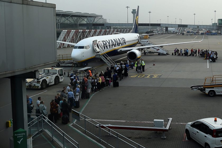 A cabin crew member serves passengers onboard a Ryanair passenger aircraft travelling from Madrid In