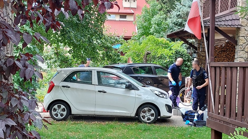 Policjanci przed domem, w którym znaleziono zwłoki małżeństwa