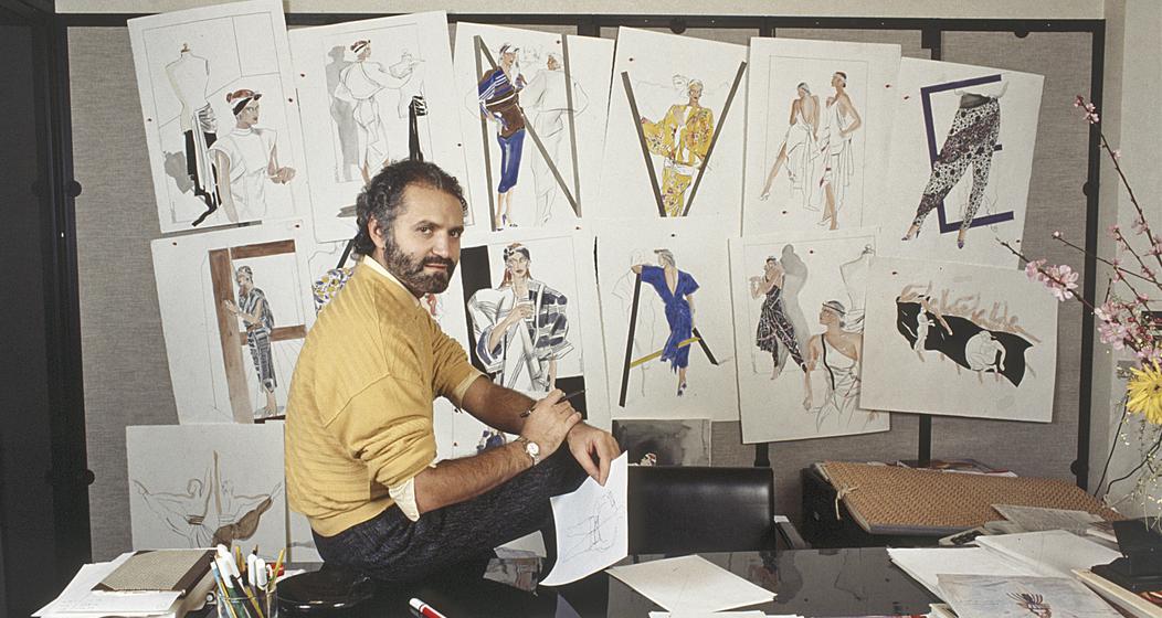 Gianni Versace 1985 in seinem Studio in Italien vor einigen seiner Mode-llustrationen. Bild: Getty Images