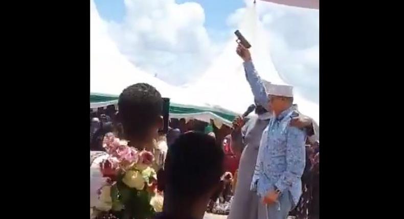 Man said to be Senator Yussuf Haji brandishing a pistol during a public function (Twitter)