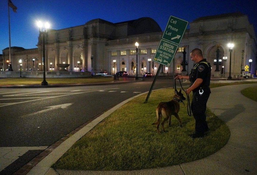Policajac sa službenim psom patrolira ispred Junion železničke i autobuske stanice u centru Vašingtona | Foto: REUTERS/Ken Cedeno