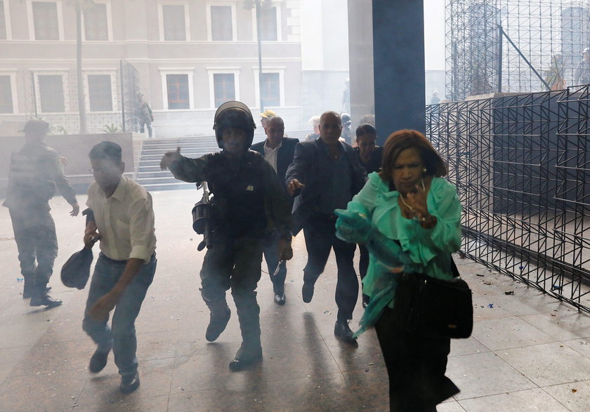 An injured government supporter is taken away by security forces after he and a group of fellow gove