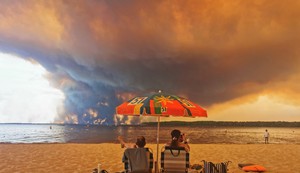 Posetioci plaže odmaraju se na plaži Mučik na obali jezera Lakano u Lakanou, na jugozapadu Francuske, dok požar besni u Žirondi, 24. jul 2026.