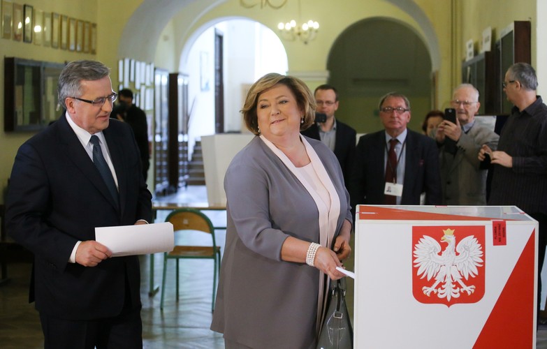 Ubiegający się o reelekcję prezydent Bronisław Komorowski (L) z małżonką Anną (C), głosują w pierwszej turze wyborów prezydenckich w lokalu wyborczym w LO im. Stefana Batorego przy ul. Myśliwieckiej w Warszawie