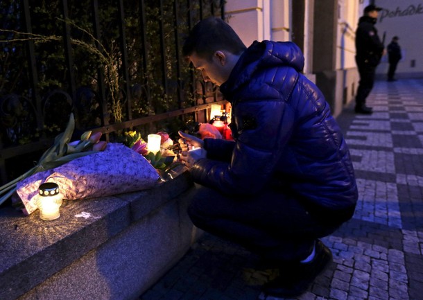 A man lights a candle in memory of the victims of today's Brussels attacks in front of the Belgian e