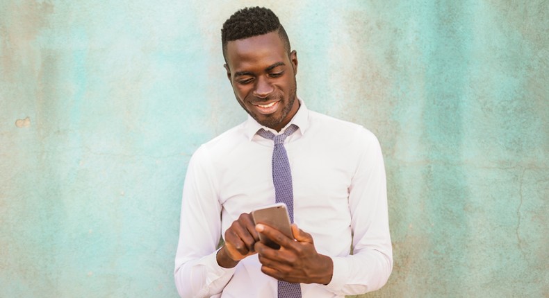 A man smiling at his phone