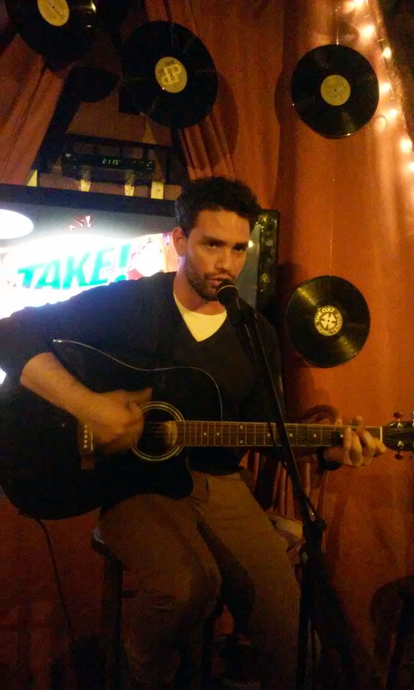 Nikola Pavlović svira gitaru i peva pesmu "Aint no sunshine" Billa Witehers - a