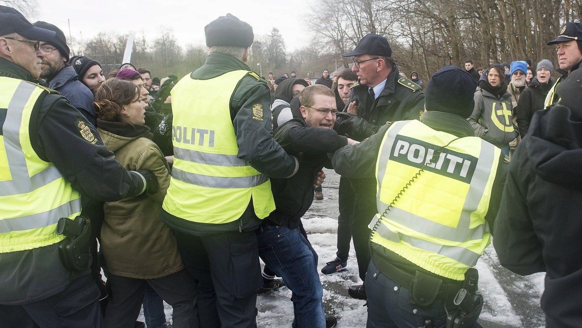 Police officers attempt to calm down people during a protest at the Danish-German border in Krusaa