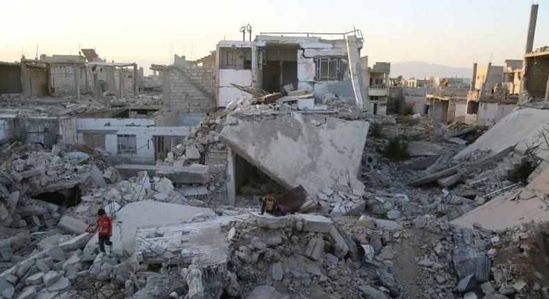 Syrian children play amidst the debris of buildings in the rebel-held town of al-Nashabiyah in the Eastern Ghouta region