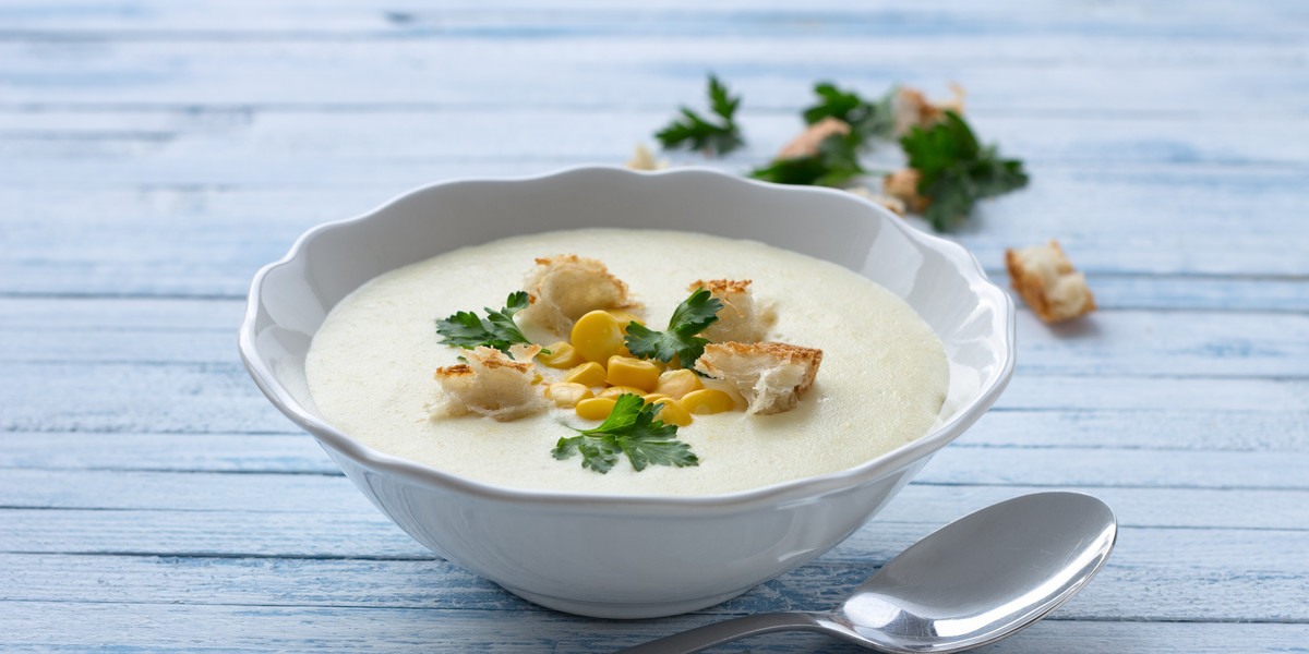 Biała warzywna zupa krem z kukurydzą, grzankami i pietruszką
