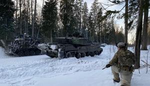 A soldier kneels in the snow in the forest next to a British Challenger 2 main battle tank (front) during a NATO exercise in Estonia.Alexander Welscher/picture alliance via Getty Images