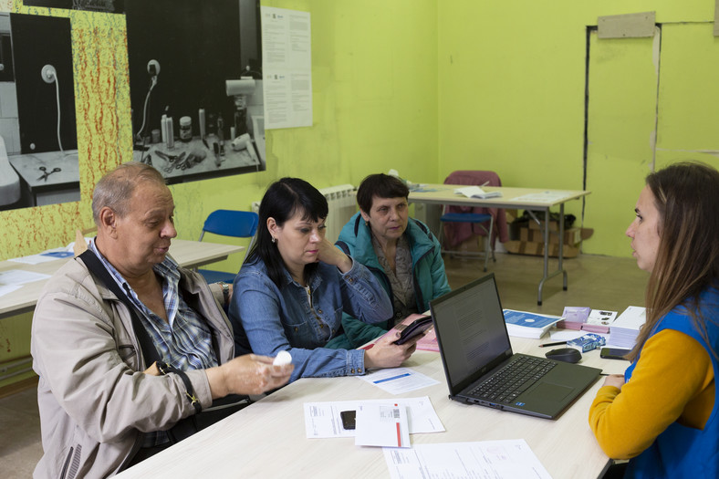 Pracownicy PAH przyjmują wnioski o pomoc pieniężną od uchodźców z Ukrainy