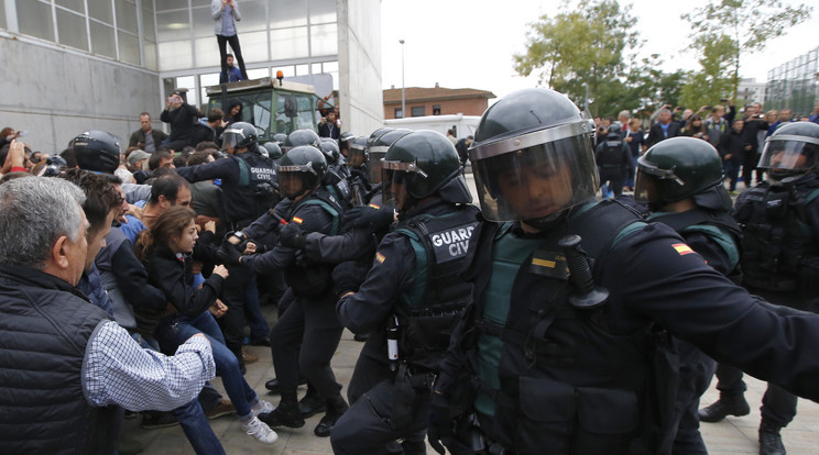 Összecsapás egy szavazóhelyiség előtt, ami előtt traktorral akadályozzák a rendőrök bejutását az épületbe /Fotó: AFP