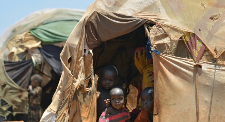 Internally displaced children appear at the entrance of a hut on March 14, 2017 at a makeshift camp on the outskirts of Baidoa, in the southwestern Bay region of Somalia