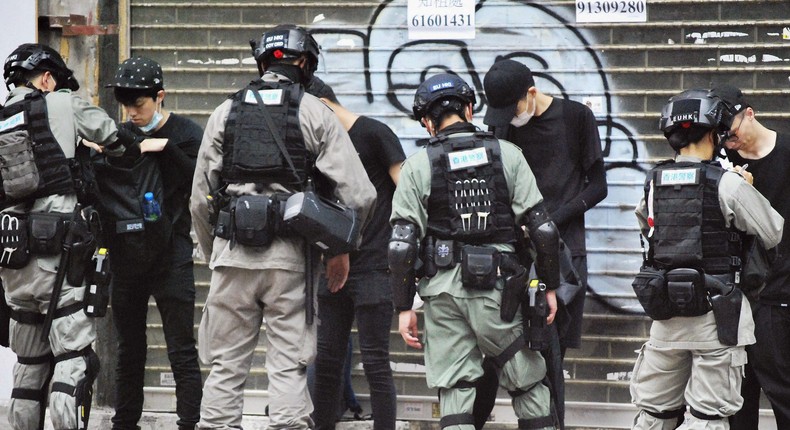 Police officers check the belongings of demonstrators in Hong Kong on July 1, 2020, the 23rd anniversary of the former British colony's handover to China. More than 10,000 people took part in a protest against Beijing's controversial national security law for Hong Kong that came into force the previous day. (Photo by Kyodo News via Getty Images)