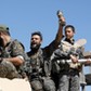 Fighters of Syrian Democratic Forces jubilate aboard an armoured fighting vehicle after Raqqa was liberated from the Islamic State militants, in Raqqa