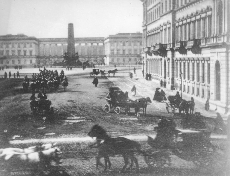 Z prawej Hotel Europejski. Widoczne dorożki i oddział rosyjskiej kawalerii. W tle widoczny pomnik oficerów-lojalistów i Pałac Saski w 1864 r.