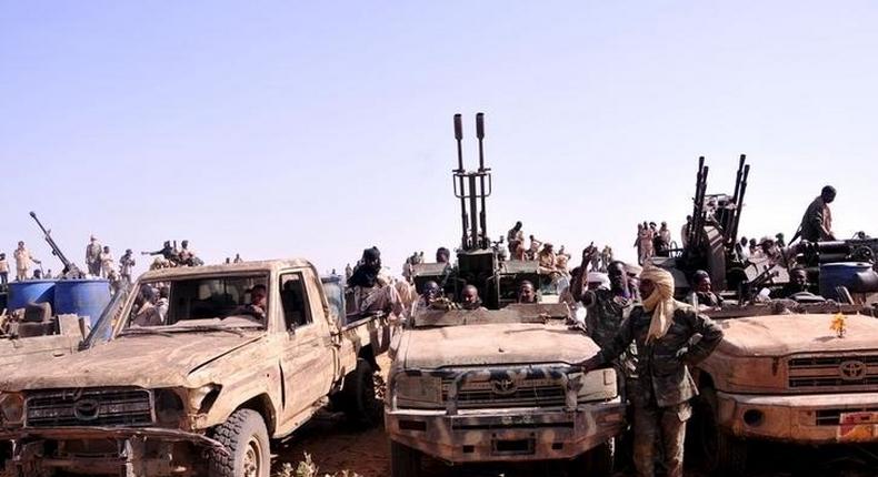 Members of the Sudanese Armed Forces (SAF) and the Rapid Support Forces (RSF) in rebel vehicles which they captured, wave to Sudanese President Omar Hassan al-Bashir as he arrives to lead victory celebrations after they defeated the Justice and Equality Movement (JEM) rebels in the Gouz Dango area in South Darfur April 28, 2015. REUTERS/Stringer