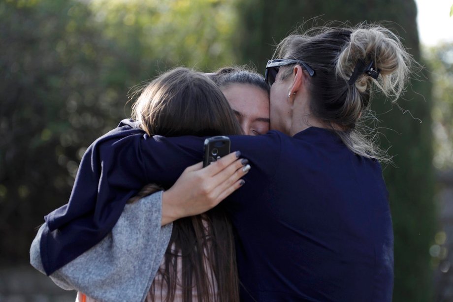 People embrace near the Tocqueville high school after a shooting has taken place injuring at least eight people, in Grasse, southern France, March 16, 2017.