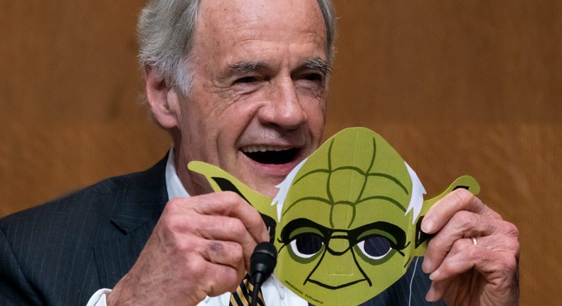 Sen. Tom Carper, chairman of the Senate Committee on Environment and Public Works, smiles as he holds a mask of Stars Wars character Yoda, on May 4, 2022.