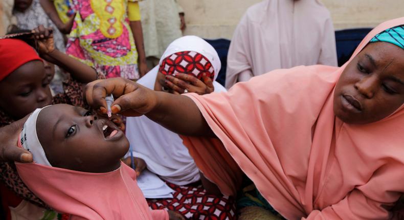 A Nigerian health official administers a polio vaccine to a child in Kano, northern Nigeria.